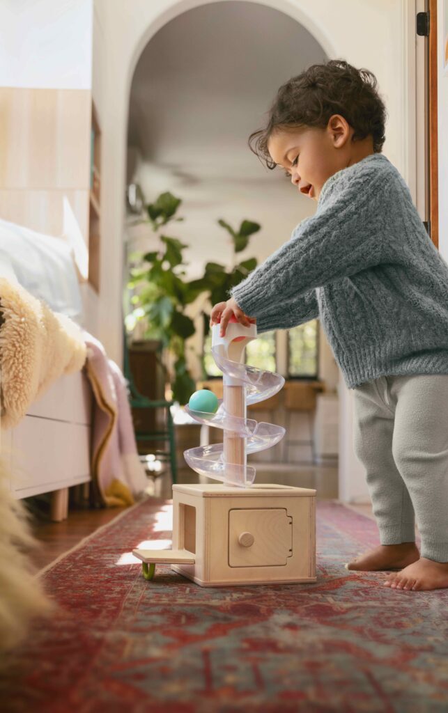 A toddler playing with a toy in a living room.